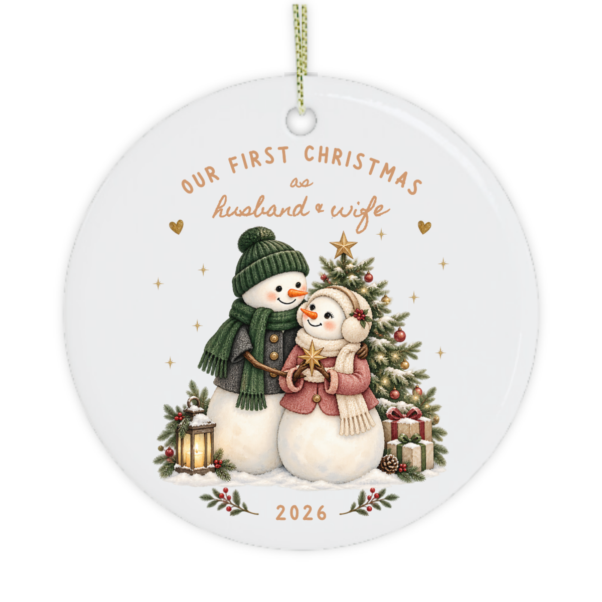 Close-up of a newlywed Christmas ornament with two snowmen, warm gold stars and blush pink and green festive details.