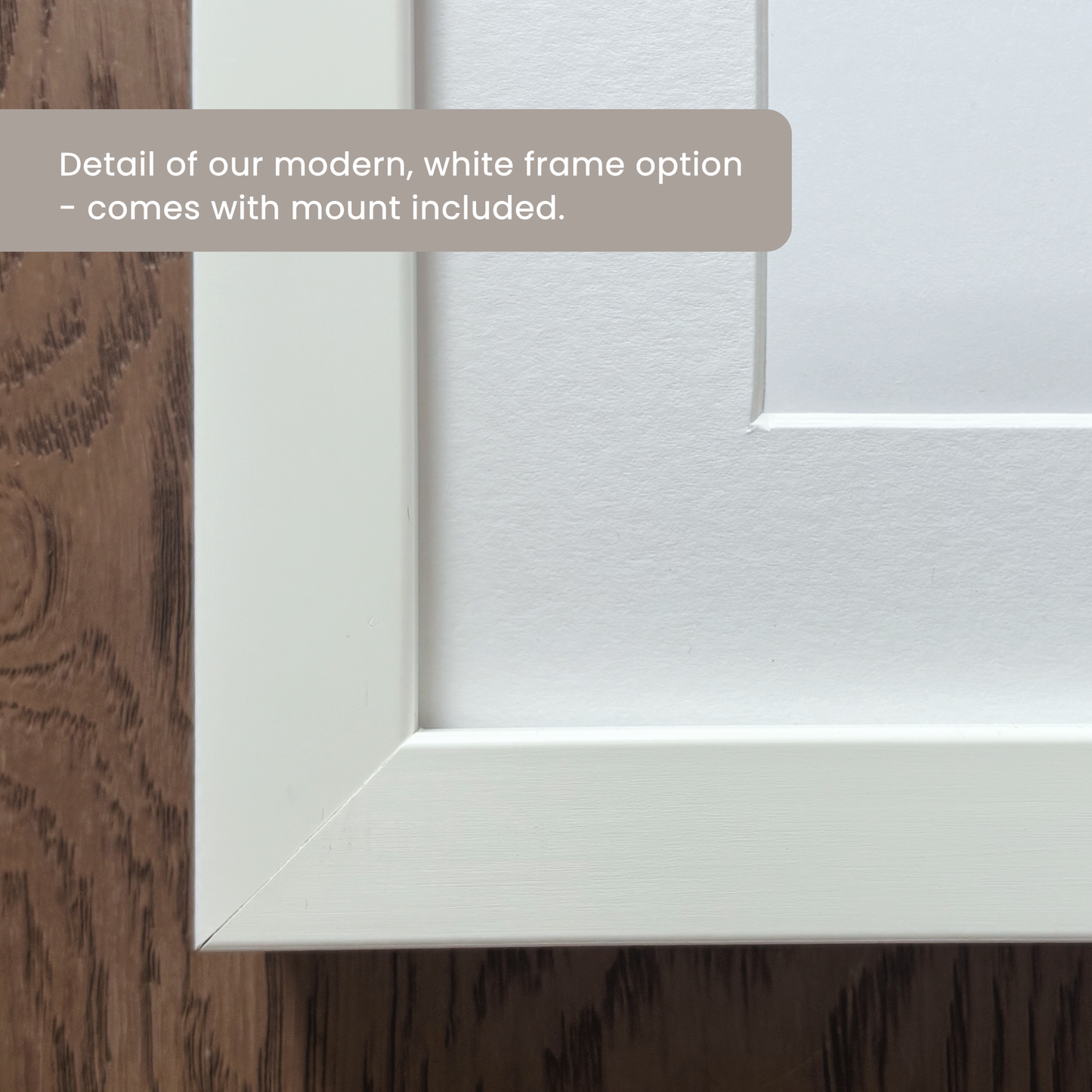Close-up corner of a willow and moon white frame option with a white matt board overlaid with the text 'Detail of our modern, white frame option - comes with mount included.'