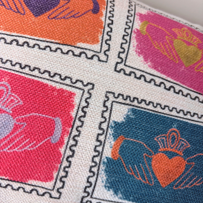 Close-up of colourful Claddagh stamp design on Irish cushion showing linen weave texture