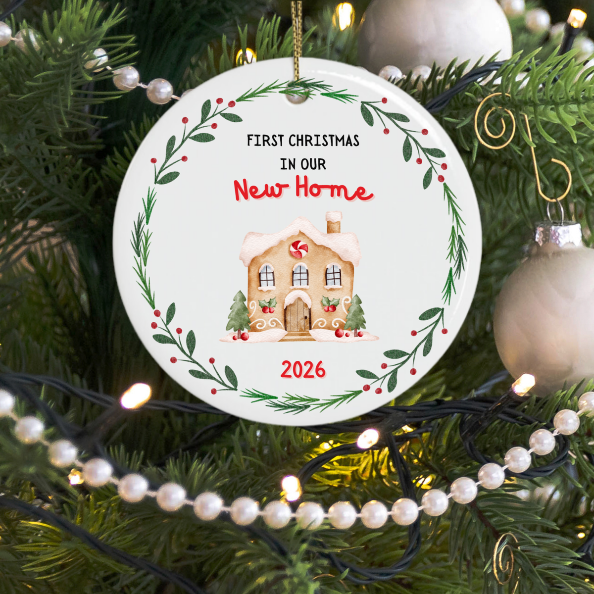 First Christmas in our new home Christmas ornament hanging on a tree with fairy lights shining behind