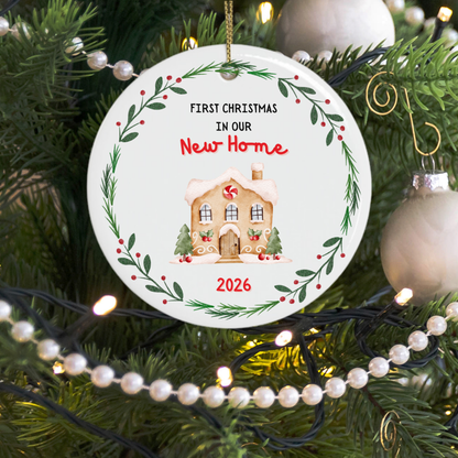 First Christmas in our new home Christmas ornament hanging on a tree with fairy lights shining behind