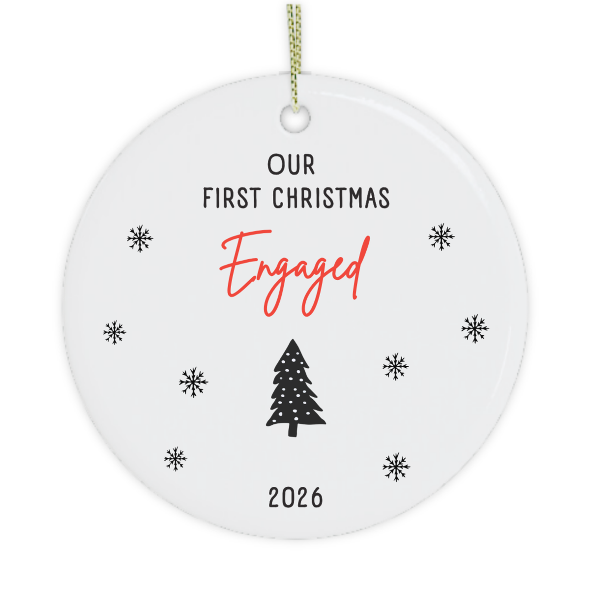 A round white ceramic Christmas ornament with a hanging loop, featuring the text 'OUR FIRST CHRISTMAS Engaged 2026' in black and red lettering, surrounded by small black snowflakes and a black Christmas tree illustration.