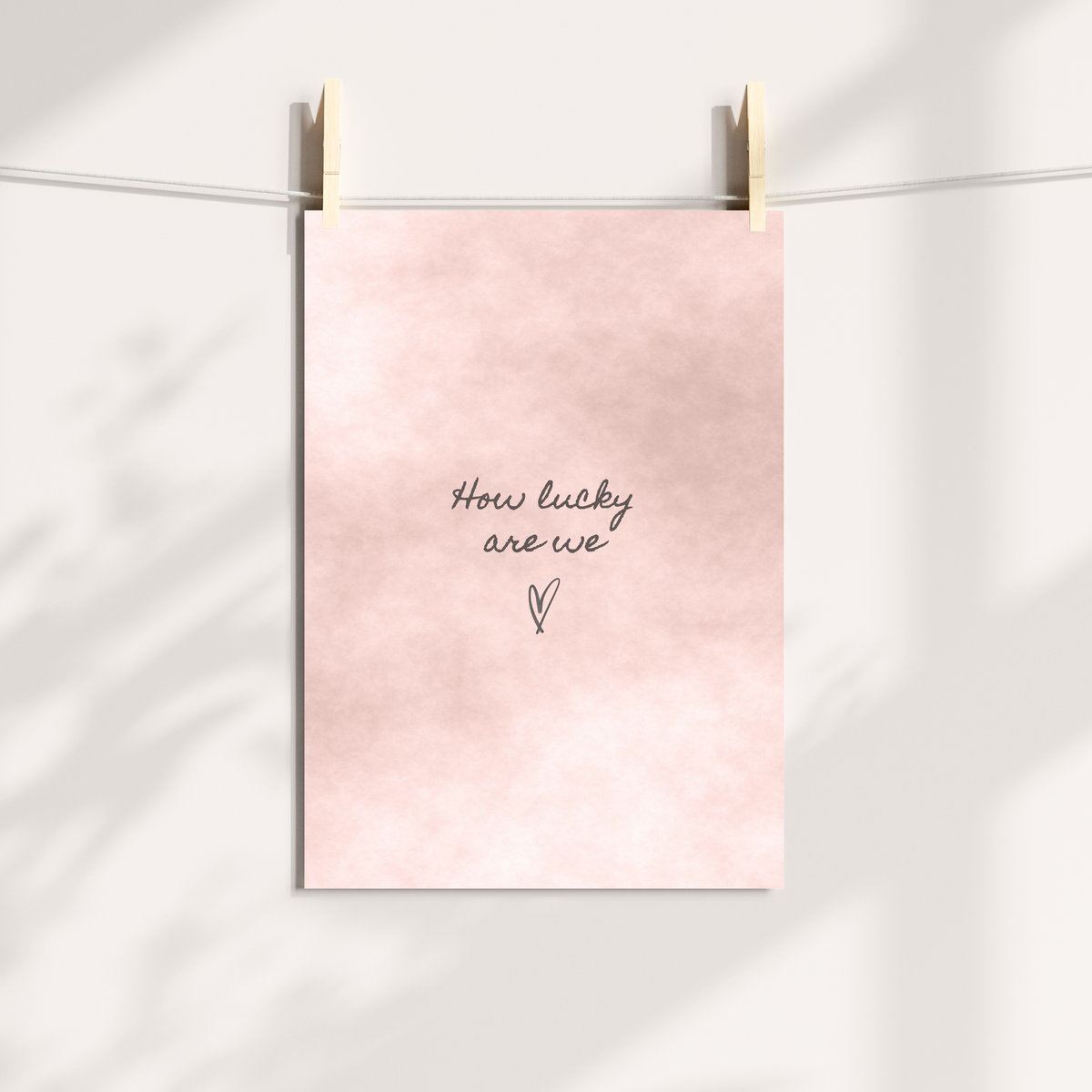 Blush pink How Lucky Are We wall art styled in a neutral home interior