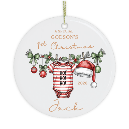 Close-up of a personalised godson's first Christmas ornament with festive baby grow illustration and name.
