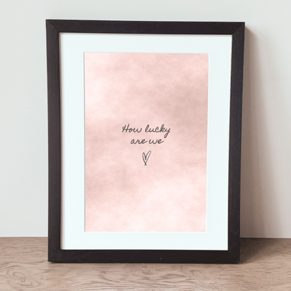 How Lucky Are We blush watercolour print in a black frame