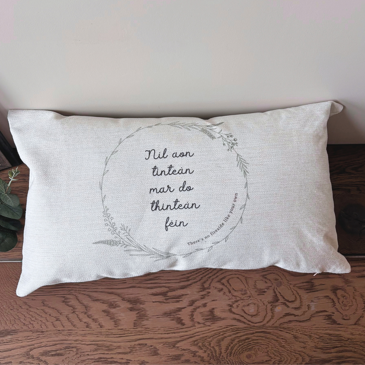 Irish language cushion Níl Aon Tinteán in natural linen-style fabric displayed in a home