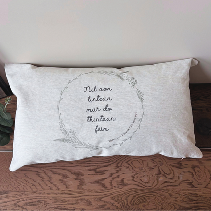Irish language cushion Níl Aon Tinteán in natural linen-style fabric displayed in a home