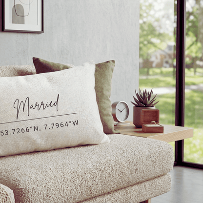 Personalised wedding cushion with married script and custom location coordinates keepsake lifestyle scene on sofa