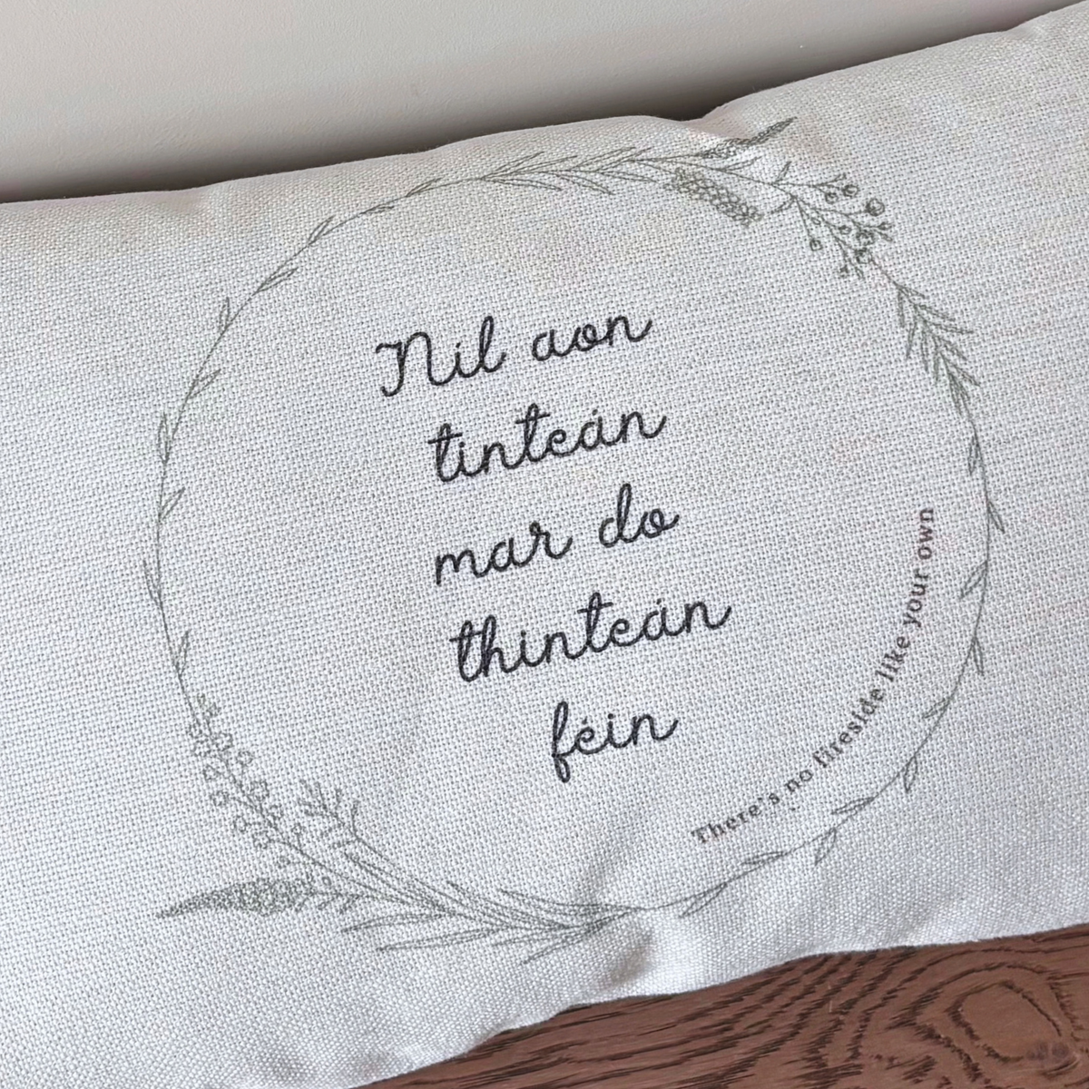 Close-up of Níl Aon Tinteán Irish saying printed on textured linen-style cushion