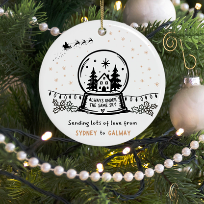 Custom Christmas tree ornament reading Always Under the Same Sky from location to location