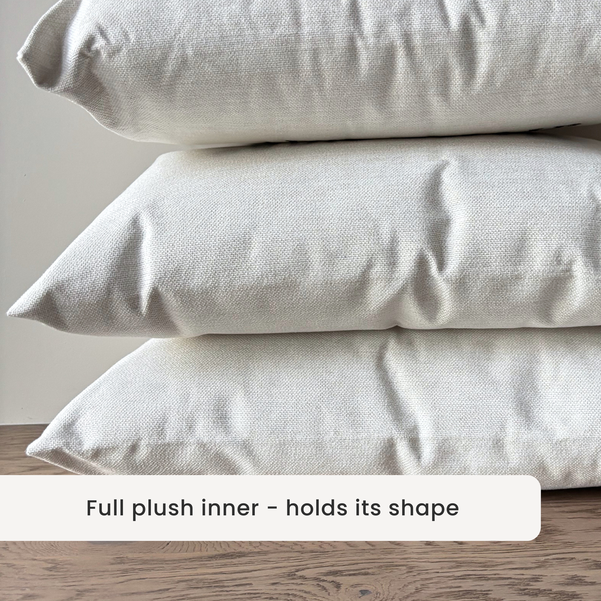 linen style fabric - Stack of three  cushions on a wooden surface with a neutral background